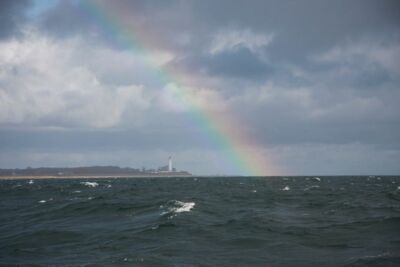 Ein im Meer endender Regenbogen vor der Ostseeküste